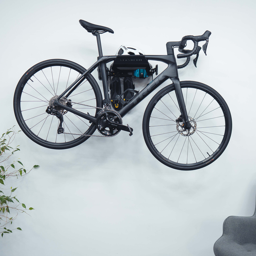Cycling kit stored on the hooks below a SpaceRail ONE bike wall mount